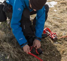 Montañero colocándose los crampones