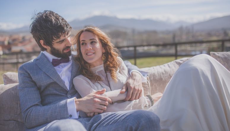 Novios en boda exterior abrazados en sillón